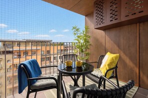 A balcony with two chairs, a small table, and a yellow cushion. - Cracow | Poznańska 10 | Comfortable Apartment | Air conditioning (Kraków)
