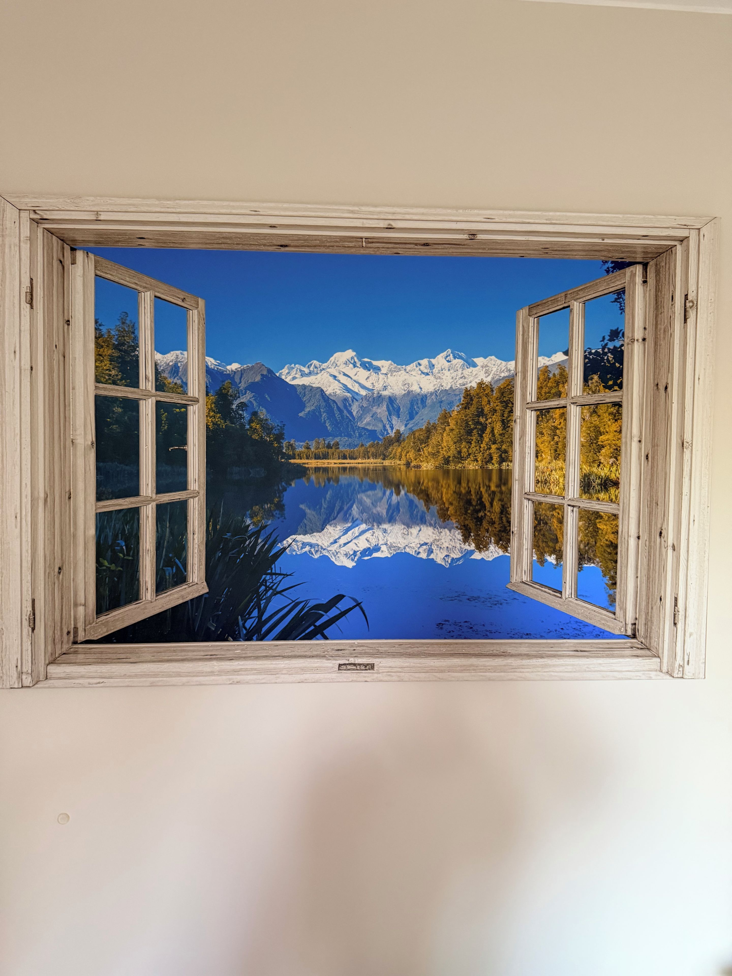 Una habitación con un ventanal que muestra un paisaje montañoso.