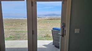 A view through a door to a balcony with a view of the beach and ocean. - Point Arena Lighthouse - Raven Studio (Point Arena)