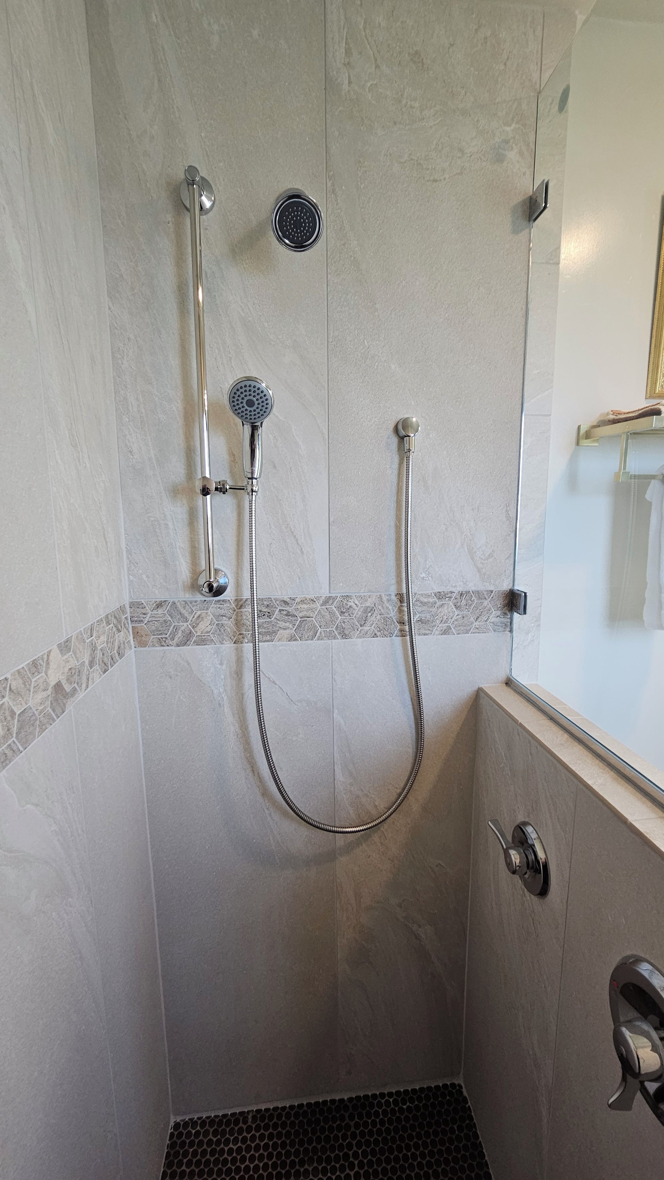 Eine Dusche mit Handbrause und fest installierter Duscharmatur.