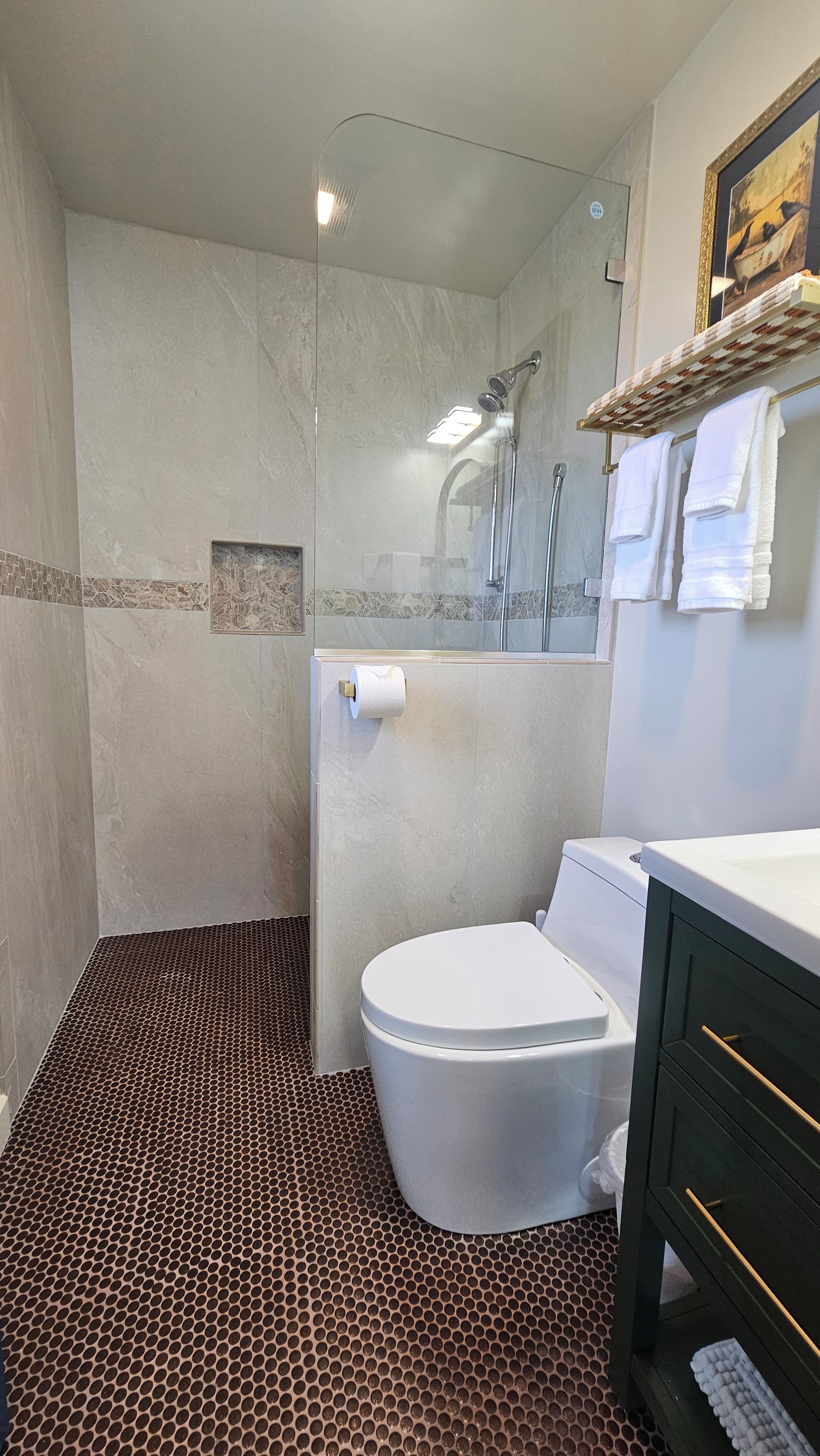 A bathroom with a shower, toilet, and sink.