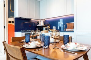 A dining area with a table set for four, including plates, glasses, and cutlery. - Urban Escape in Business Bay (Dubai)
