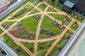 A landscaped courtyard with pathways, benches, and planters. - Katowice | Zabrska 15 | Modern Apartment | Air conditioning (Katowice)