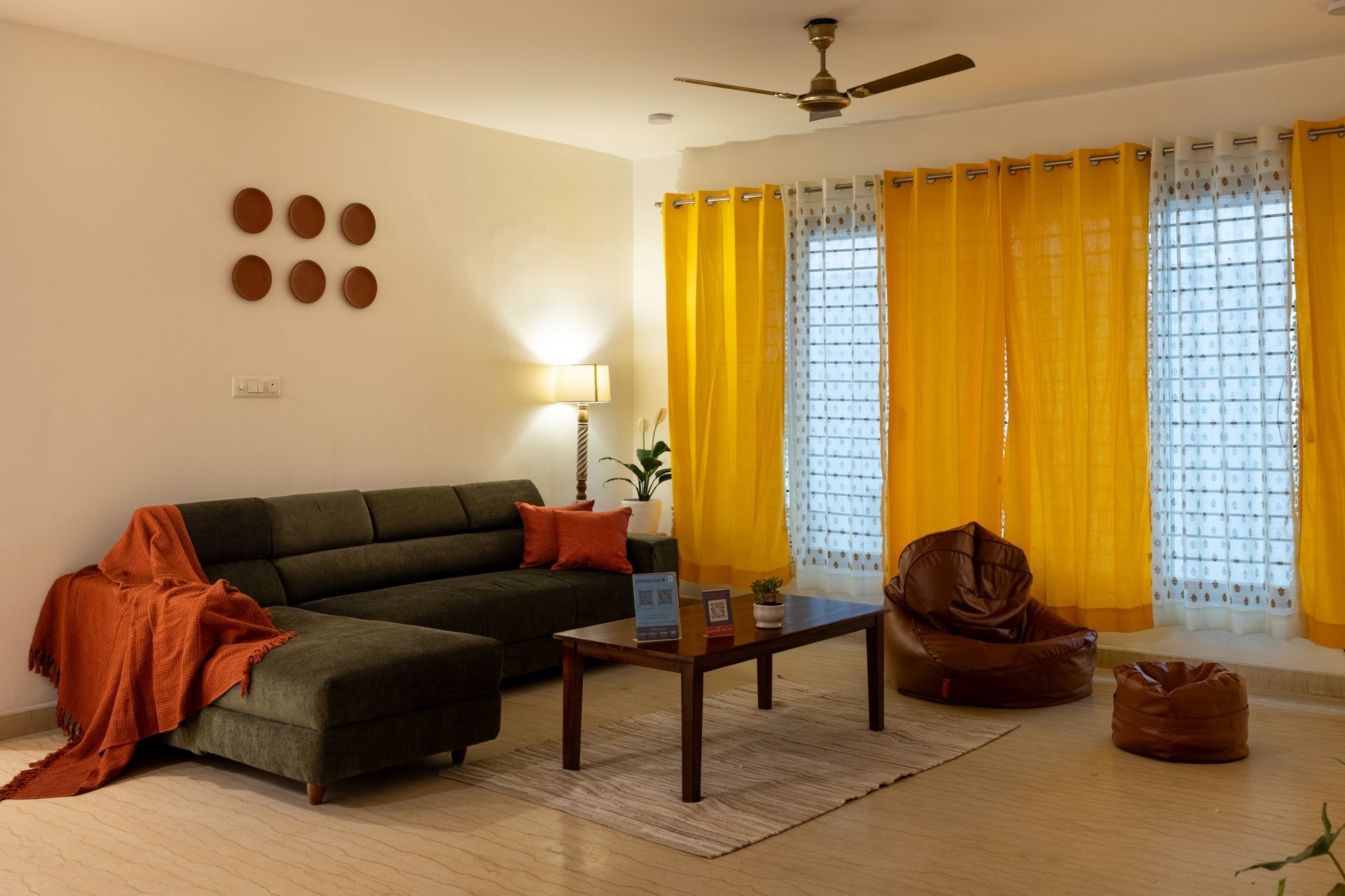 A living room with a sofa, a coffee table, a chair, and a ceiling fan.