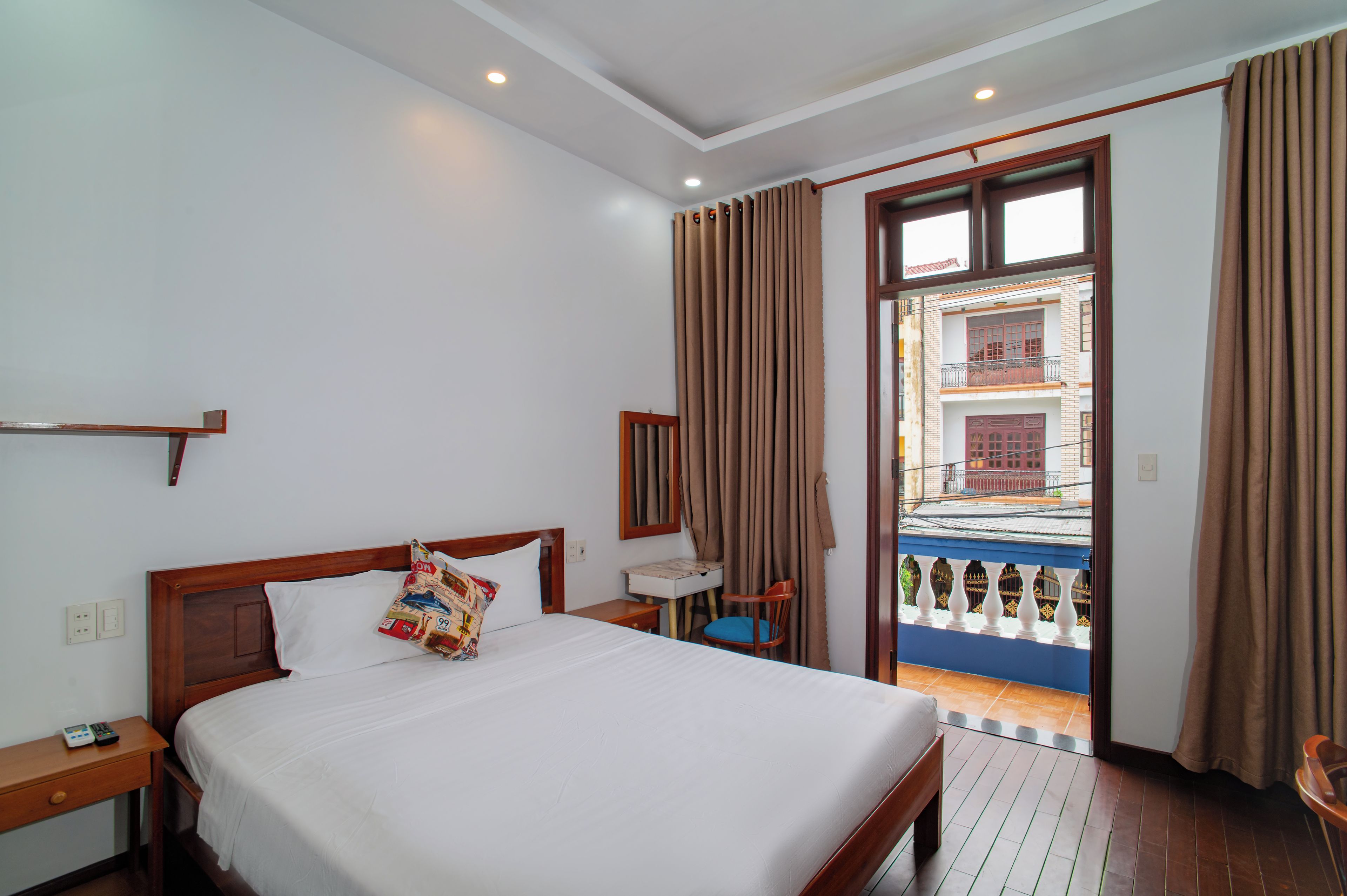 Une chambre d’hôtel avec un lit, une table de chevet, une chaise et une vue sur l’extérieur.