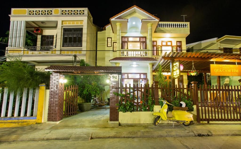 A two-story building with a gated entrance, a scooter parked in front, and a sign indicating a restaurant.