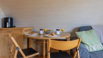 Une cuisine de taille réduite comprenant une table à manger, des chaises et un canapé.