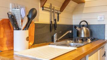 A compact kitchen with a wooden countertop, a built-in oven, and a sink.