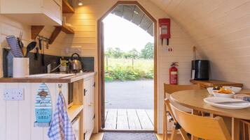 A cozy kitchen with wooden cabinets, a dining table, and a view of the outdoors.