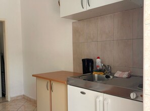 Eine Küche mit Arbeitsplatte, Spüle und Schränken.