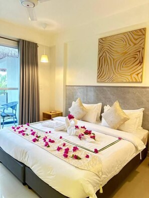 A hotel room with a bed, a nightstand, a wall-mounted artwork, and a view through a window. - YUVi blue maldives (Himmafushi)