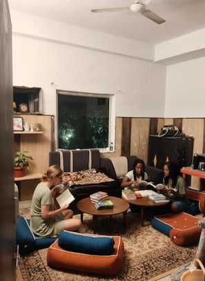 A living room with a sofa, coffee table, and a large window. - Hotel NoVo Agra (Agra)