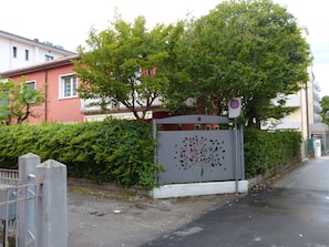 A gated entrance with a decorative metal gate, a no parking sign, and a building with a red facade in the background. - Beautiful apartment in Jesolo, PVT parking (Città Metropolitana di Venezia)