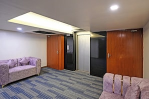 A room with a purple sofa, a wooden wardrobe, and a sliding door closet. - Palette Madhapur (Hyderabad)