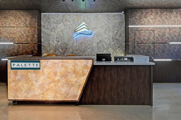A reception desk with a marble top labeled 'PALETTE,' a logo above it, and a wooden panel to the right. - Palette Madhapur (Hyderabad)