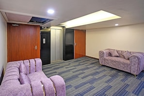 A hotel room with a large bed, a sofa, a massage chair, and a minibar. - Palette Madhapur (Hyderabad)