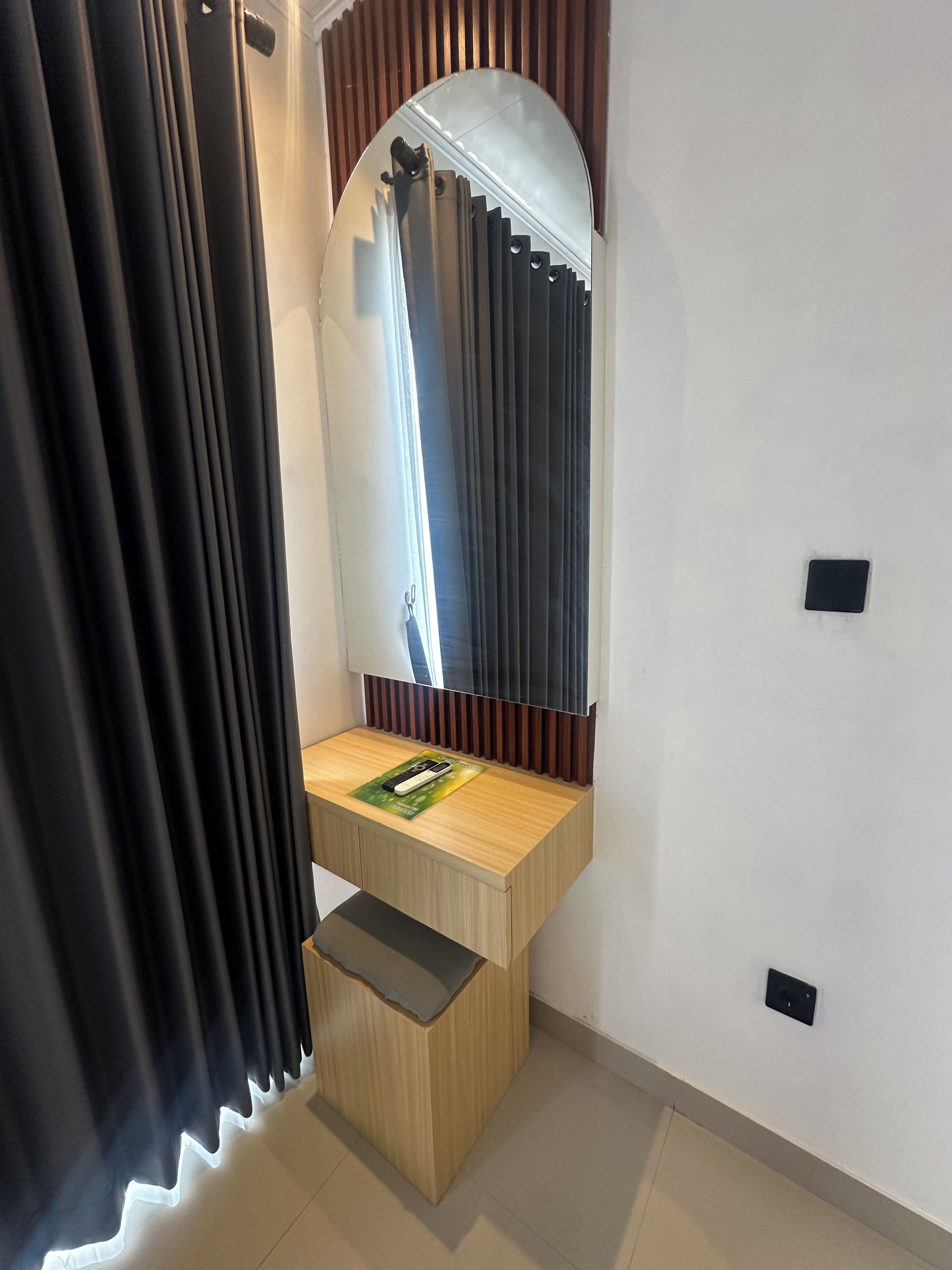 A bathroom with a wooden vanity, a mirror, and a towel rack.