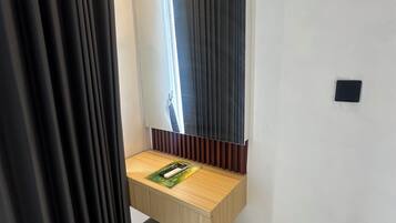 A bathroom with a wooden vanity, a mirror, and a towel rack.
