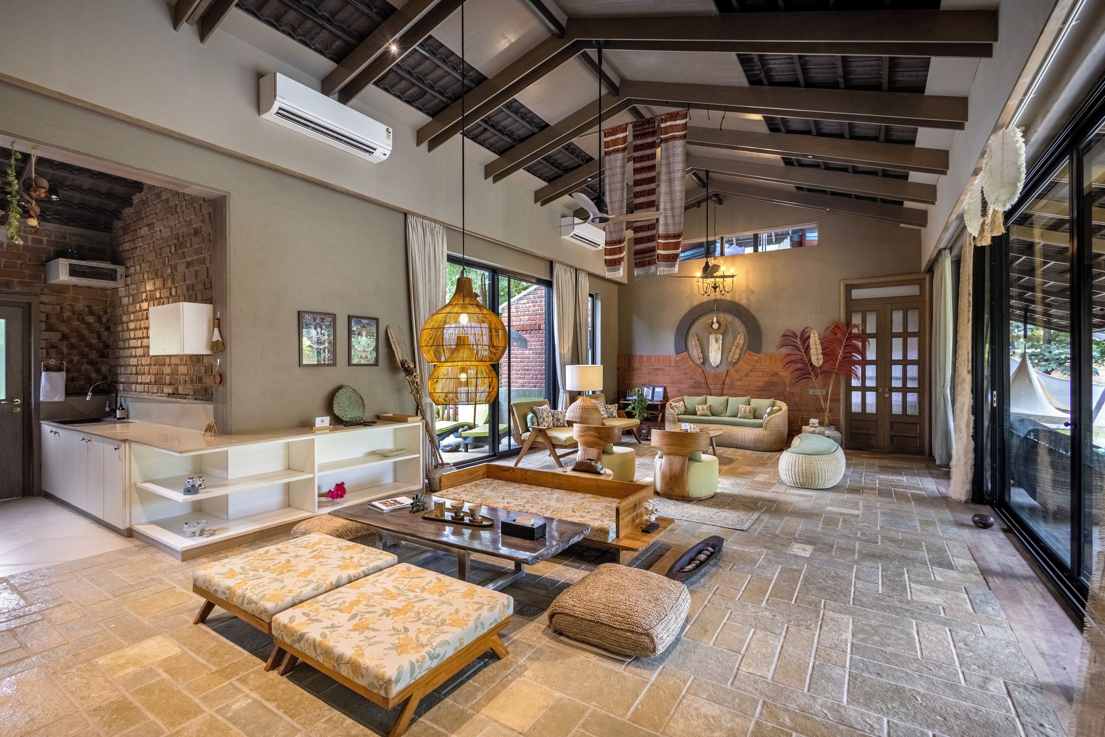 A spacious living area with a high ceiling, a fireplace, and a large window providing a view of the outdoors.