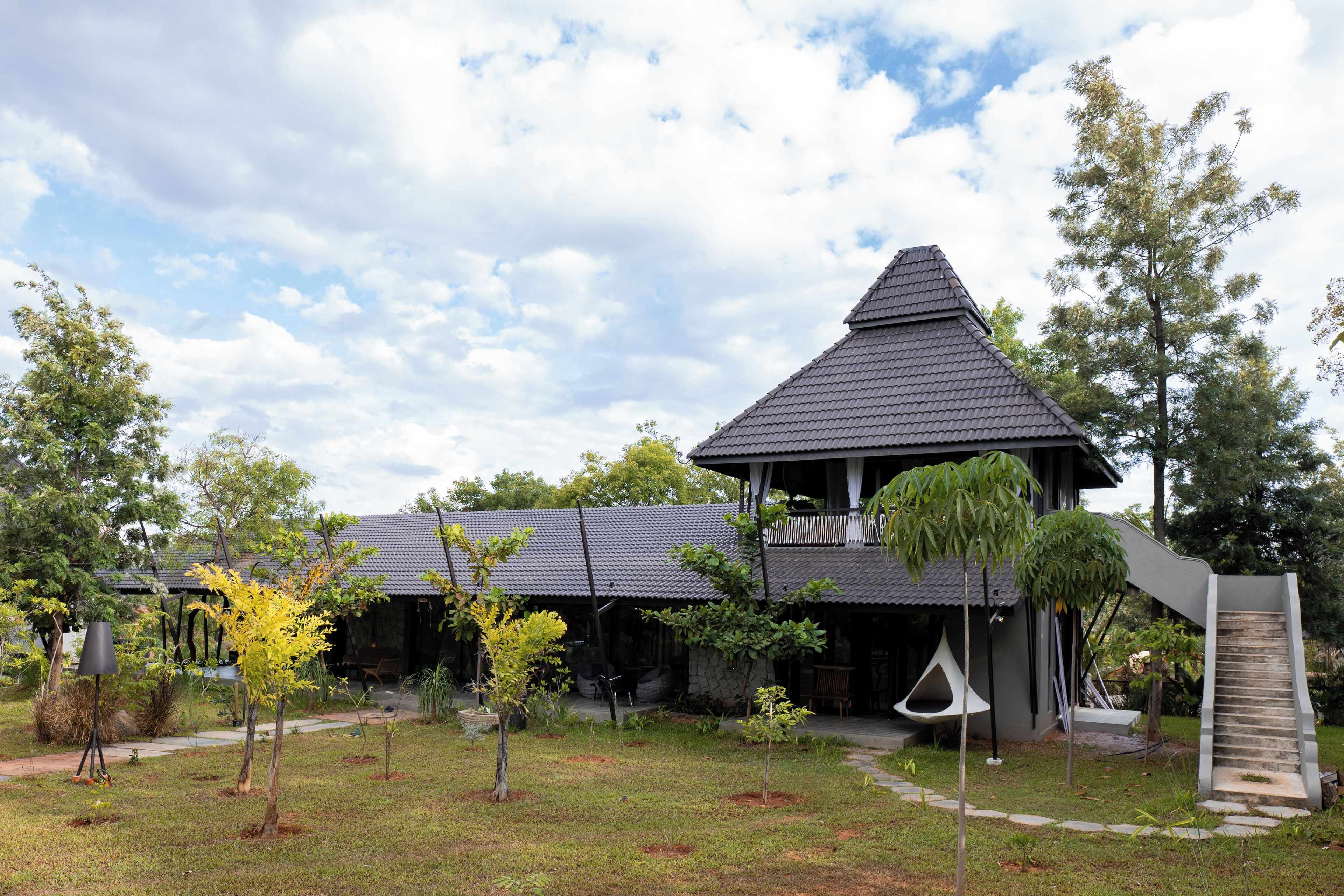 A building with a peaked roof, a covered porch, and a staircase leading to an upper level.