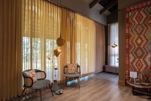 Una habitación con dos sillas, una mesita y un tapete estampado.