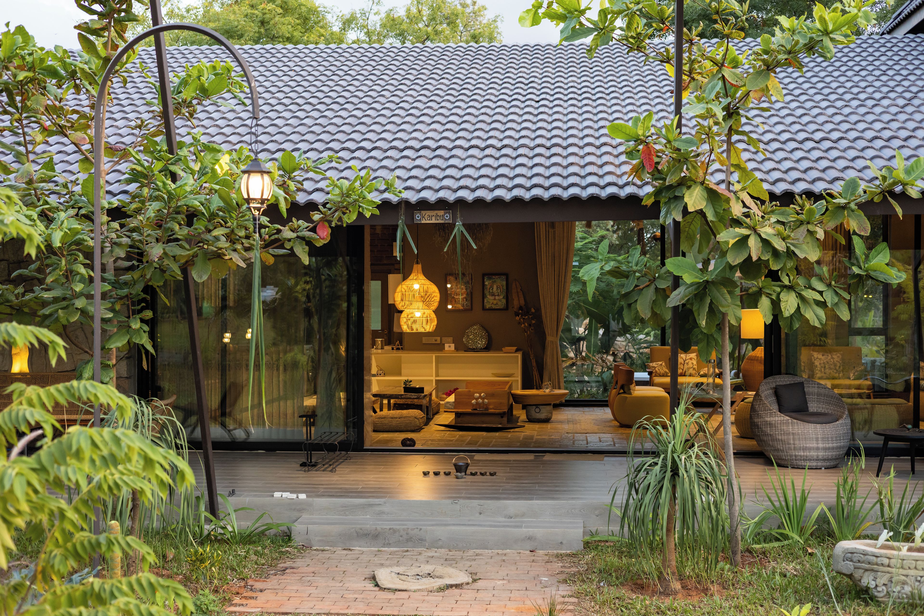 Une maison moderne avec un toit en tuiles, une entrée en verre et un intérieur chaleureux agrémenté de meubles.