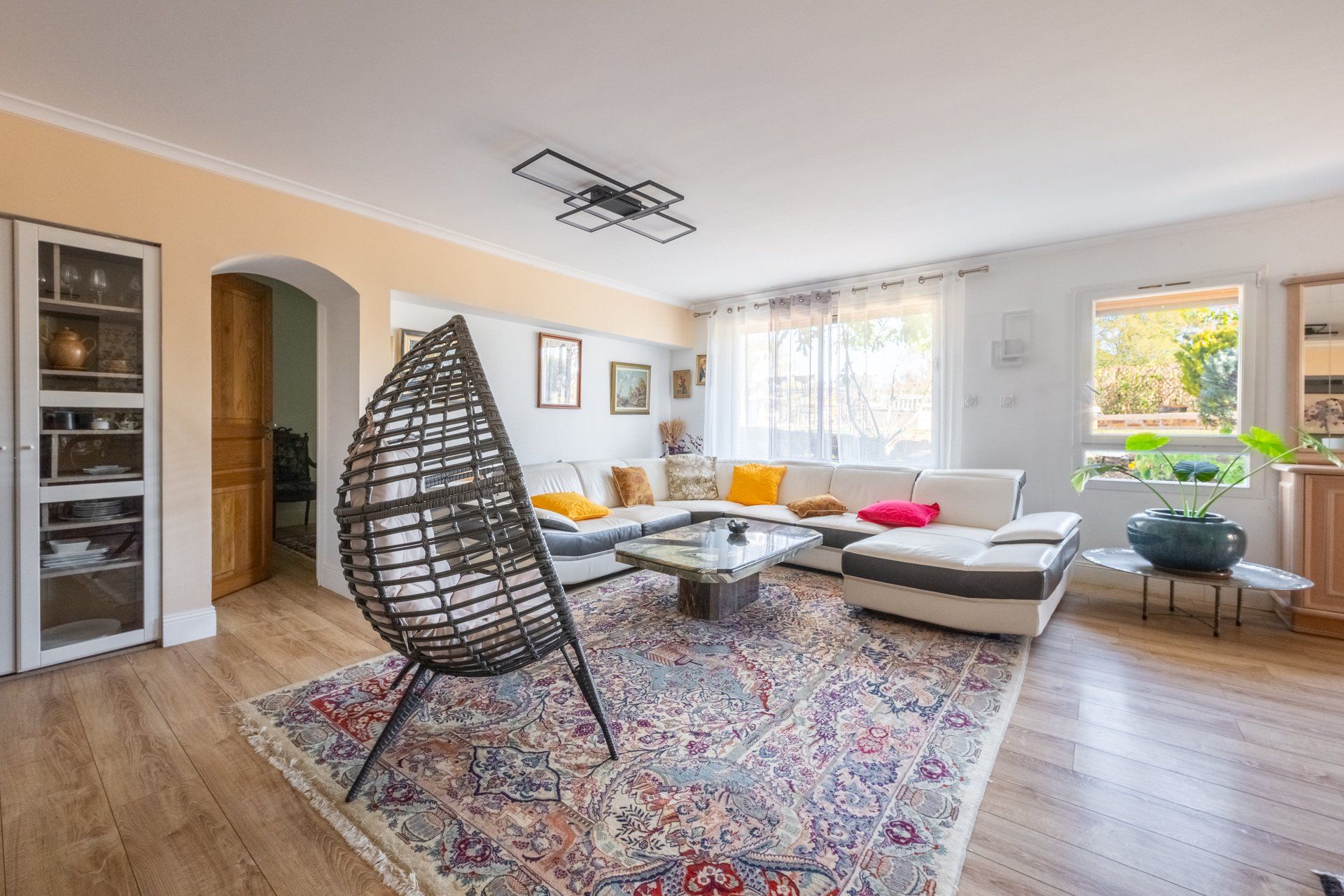 A living room with a sofa, a coffee table, a patterned rug, and a unique chair.