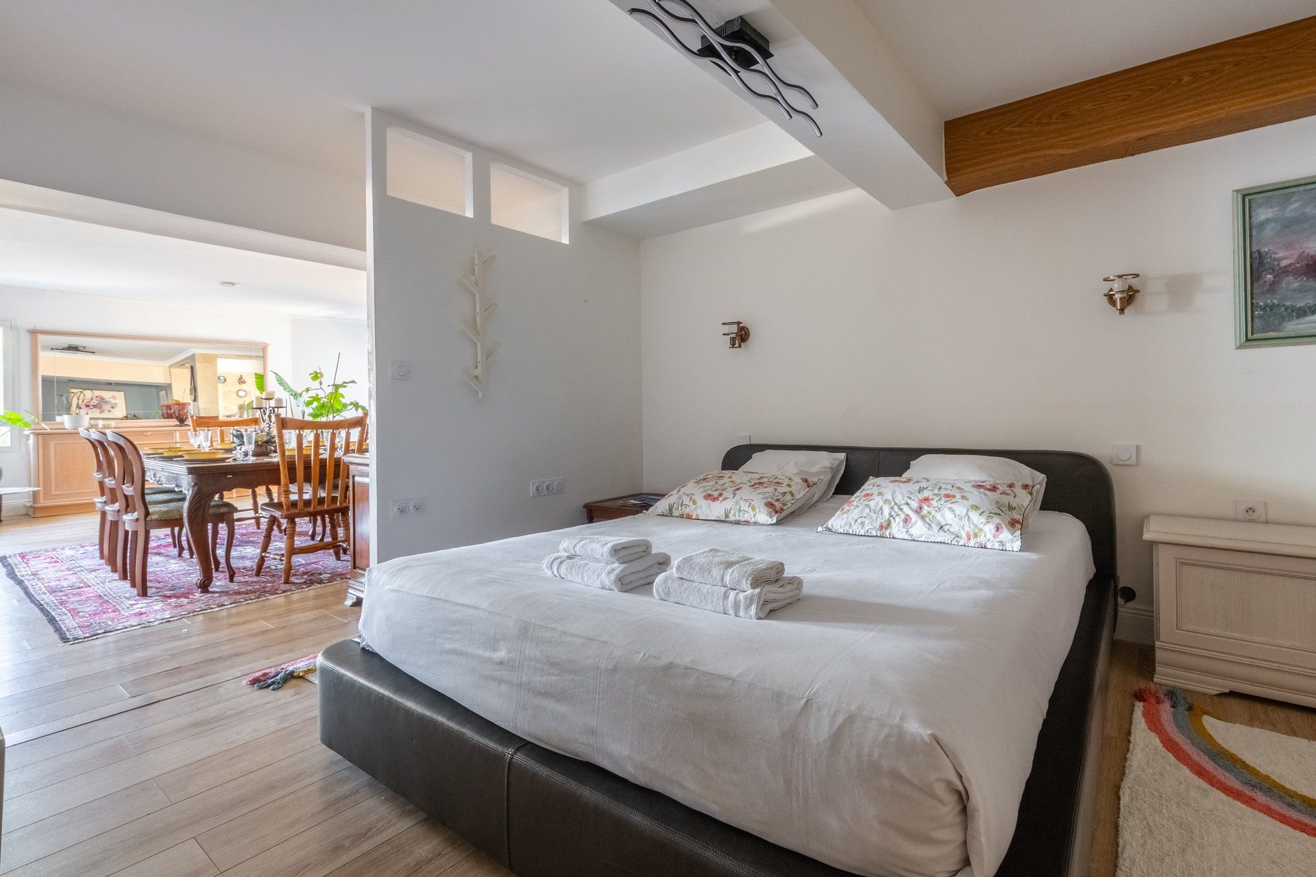 Une chambre à coucher avec un grand lit, une tête de lit en bois et une table de chevet.