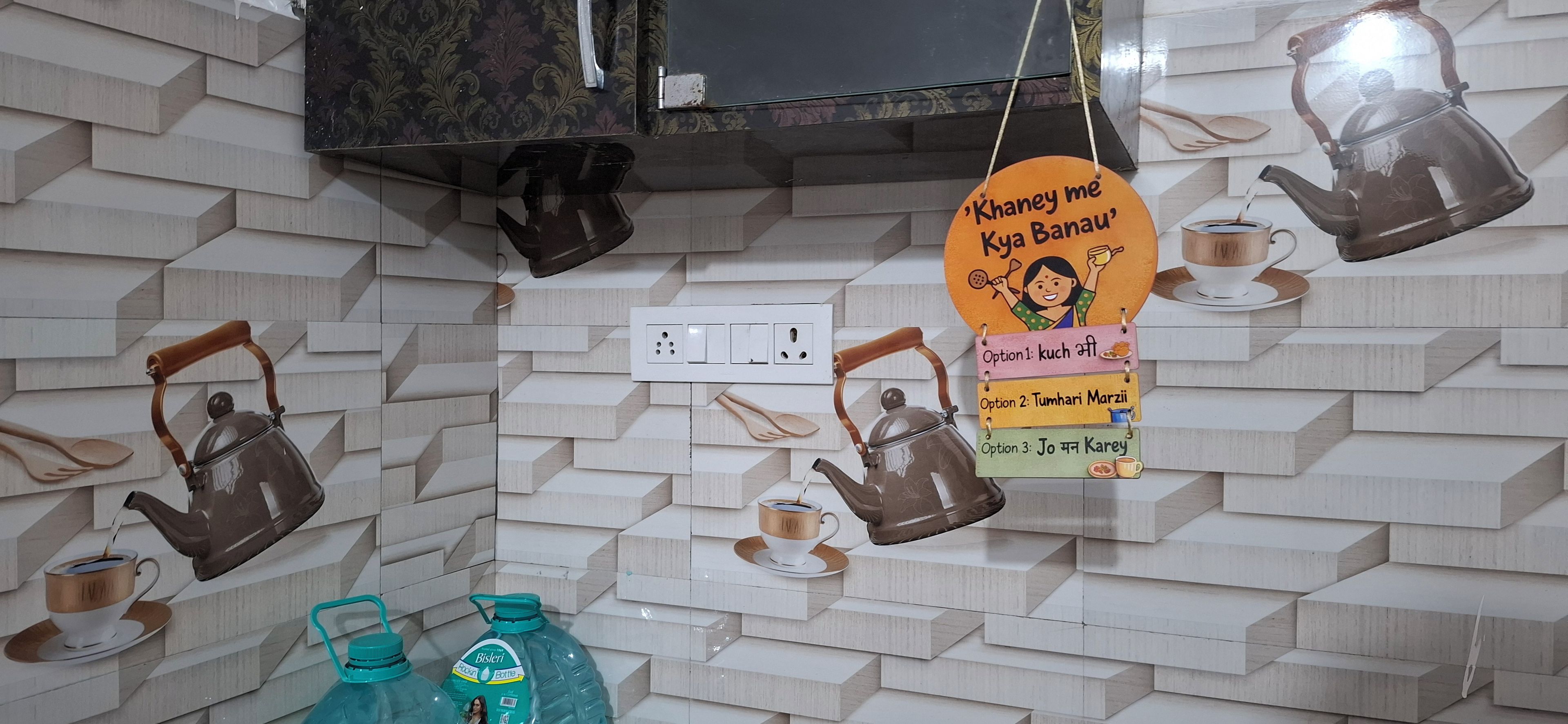 Eine Küche mit modernem Design, inklusive einer Wand mit Musterfliesen, hängenden Wasserkochern und einem an der Wand befestigten Schild mit Teesorten.