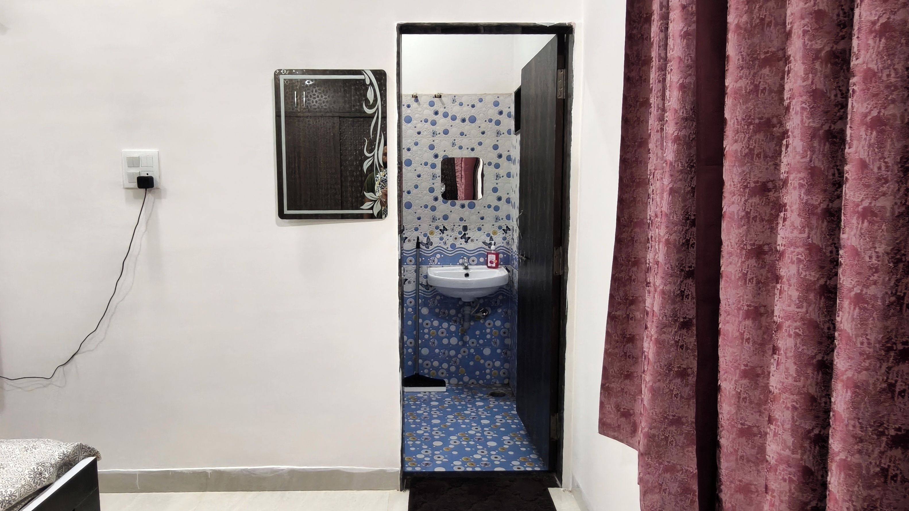 A bathroom with a white sink, a mirror, and a patterned floor.