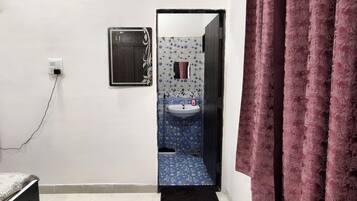 A bathroom with a white sink, a mirror, and a patterned floor.