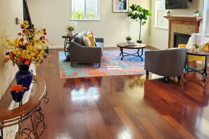 Un salon doté d’un parquet, d’un canapé, d’une table basse et d’une cheminée.