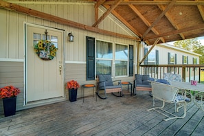 A covered porch with a wooden floor, a table, and four chairs. - Explore Oklahoma! Grand Lake - Rock Crawling (Jay)