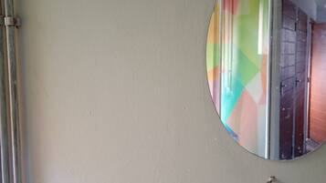 A round mirror on a wall with a visible reflection of a room.