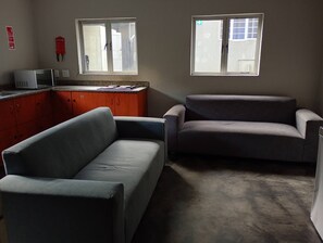 Ett rum med två soffor, en mikrovågsugn och ett fönster med utsikt.