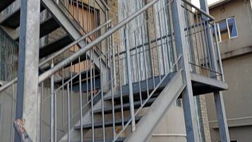 A multi-story building with external metal staircases and balconies.