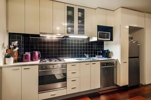 A modern kitchen with stainless steel appliances, a microwave, and a dishwasher. - Monroe X Banksy Loft | Luxury CBD Stay| Pool & Gym (Melbourne)
