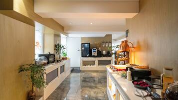 Een moderne keuken met een marmeren vloer, een koffieapparaat en diverse keukenapparaten.