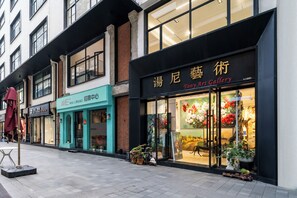 A street view with storefronts, including a Tony Art Gallery with floral artwork. - Weiting Hotel Shanghai Stadium Xujiahui (Shanghai)