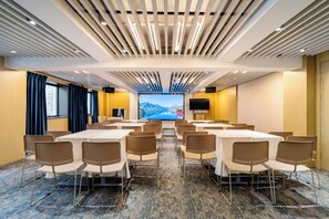 A conference room with a large screen, multiple tables, and chairs arranged for meetings. - Weiting Hotel Shanghai Stadium Xujiahui (Shanghai)