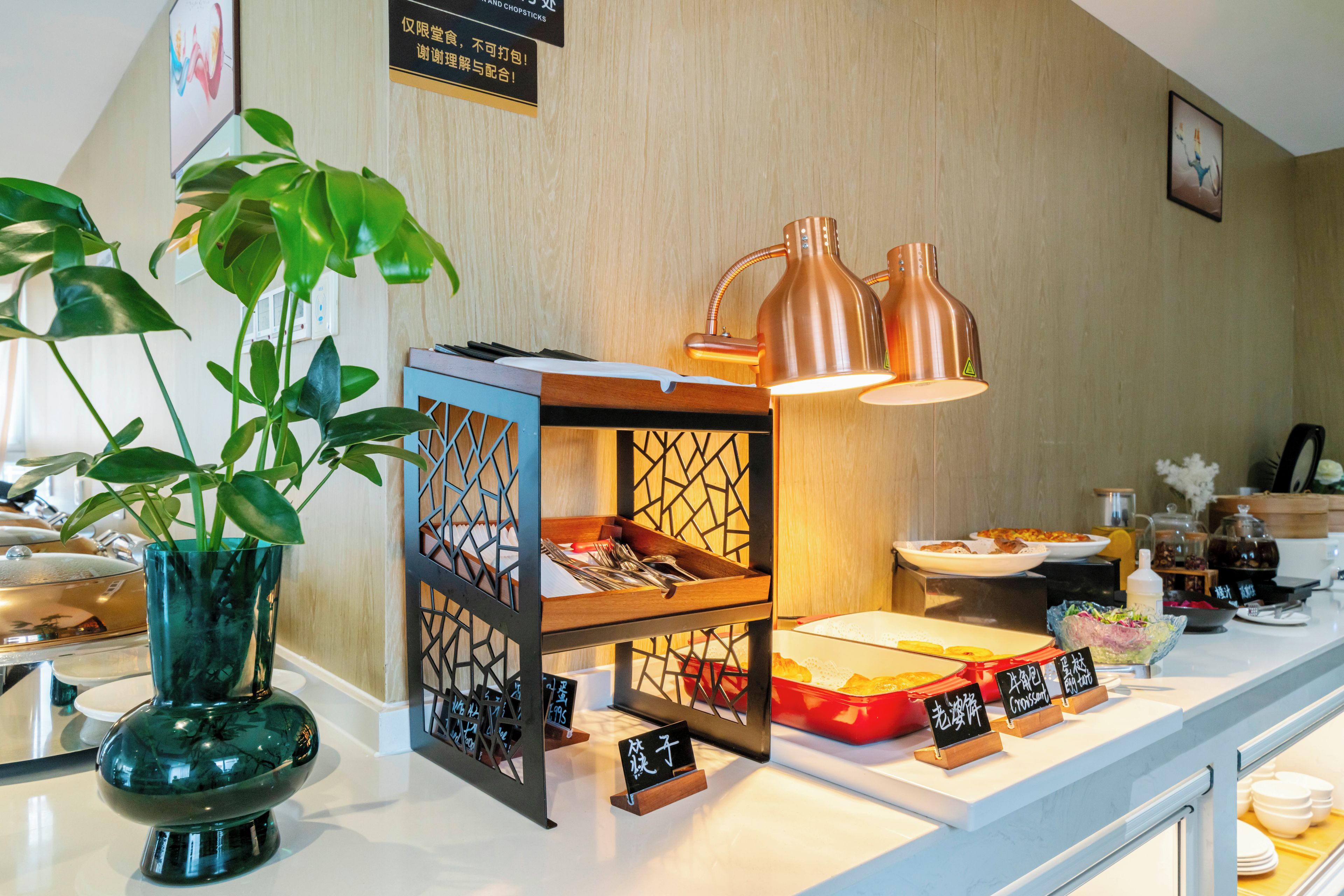 Un comptoir agrémenté d’une plante, un meuble décoratif et un panneau avec des caractères chinois.