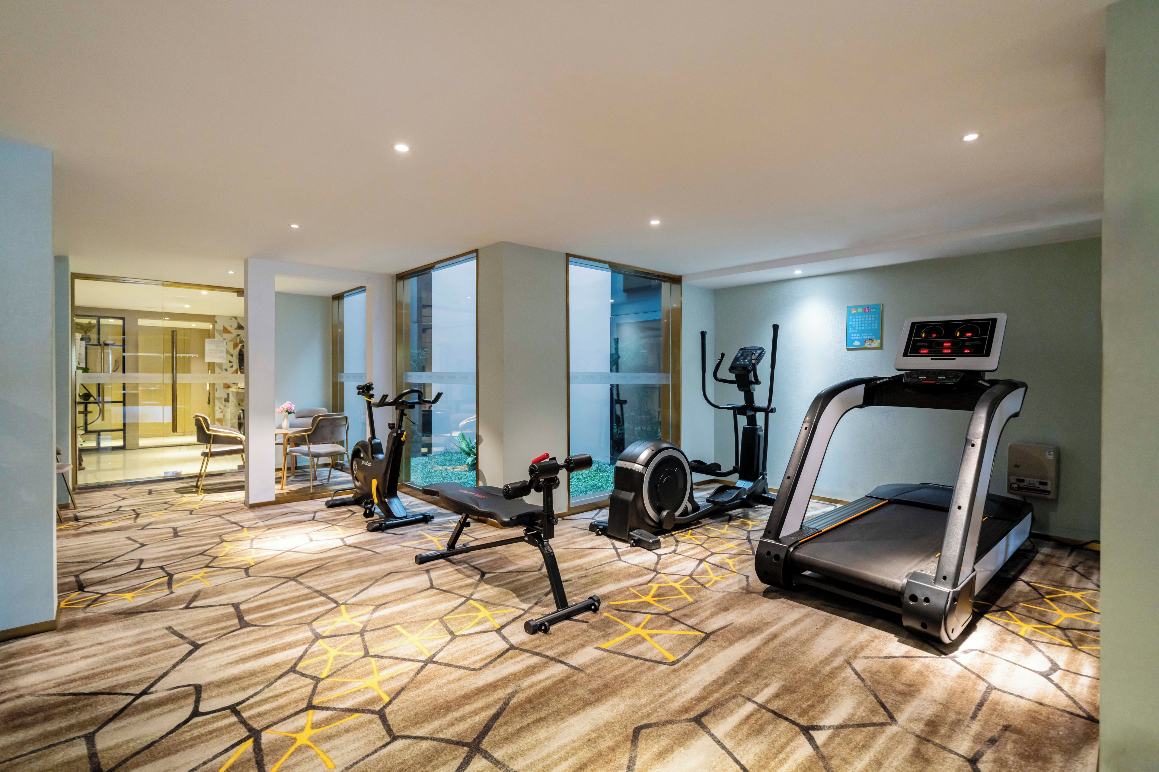 A fitness room with cardio equipment, a treadmill, and a stationary bike.