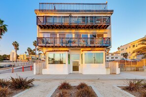 A two-story building with a balcony, large windows, and a gated entrance. - Boardwalk Escape: Beachfront Santa Monica Condo (Santa Monica)