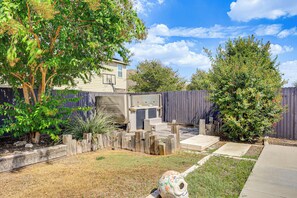 A backyard with a wooden fence, a tree, and a house. - Hot Tub & Patio! Family Escape, 7 Mi to SeaWorld (San Antonio)