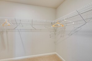 A corner of a room with a white wall and a white ceiling. There is a white metal rack with multiple hooks for hanging items. - Hot Tub & Patio! Family Escape, 7 Mi to SeaWorld (San Antonio)