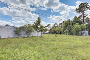 A grassy field with scattered flowers, a white fence, and trees in the background. - Port St. Lucie Home on Florida's Treasure Coast (Port St. Lucie)