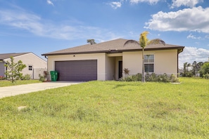 A single-story house with a garage, a lawn, and a clear sky. - Port St. Lucie Home on Florida's Treasure Coast (Port St. Lucie)