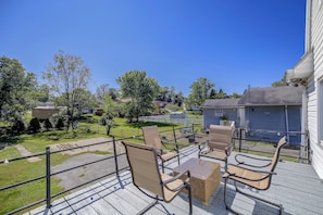 Eine Terrasse mit Gartenmöbeln, Blick auf eine Wohngegend und einem strahlend blauen Himmel.