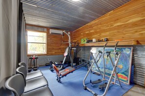 A gym with exercise equipment, a blue mat floor, and a large world map on the wall. - 1/2 Mi to Lake Tenkiller Condo w/ Shared Game Room (Cookson)