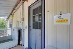 Ein Gebäudeeingang mit einer Tür, auf der 'UNIT THIS WAY' steht, und einem Schild mit der Aufschrift 'UNITS IN HERE'.